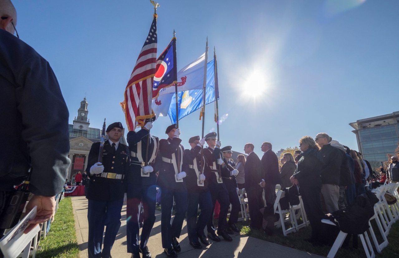 military members carrying flags during a veterans day ceremony