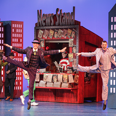 Two CCM student do toe-touches on stage